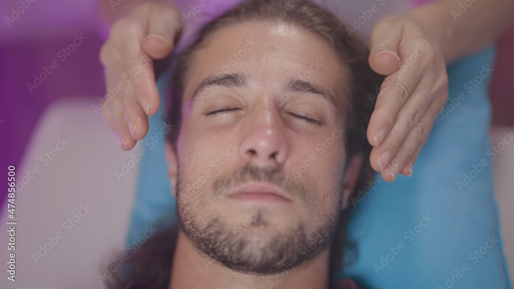 Obraz premium Touchless hand healing action on person head close-up top view