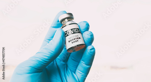 The nurse holding the covid vaccine booster shot in hand