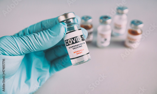 The nurse holding the covid vaccine booster shot in hand
