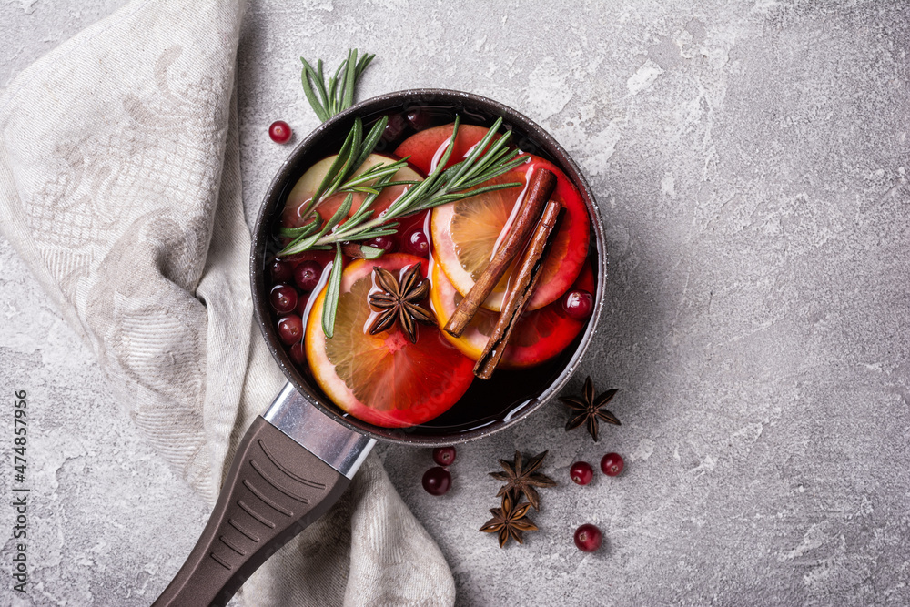 Mulled wine with slices of citrus fruits, berries and aromatic spices