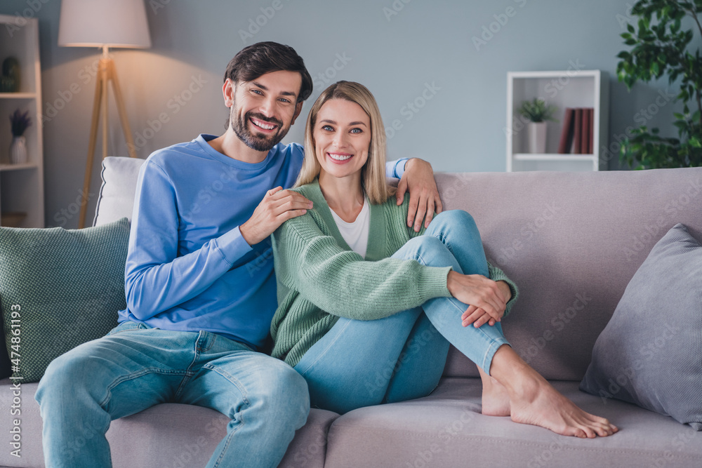Portrait of two adorable attractive cheerful people sitting resting on divan peaceful life at home indoors