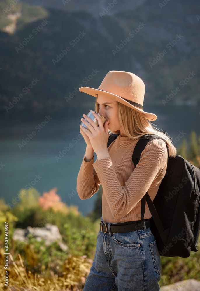 A tourist girl is resting after a hard climb up the mountain.