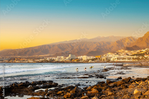 Playa de las Americas. Surfers on the beach in Tenerife at sunset photo