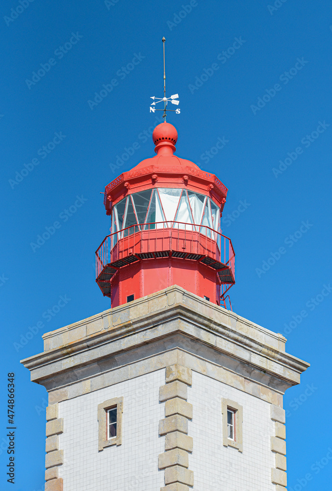 Close up of red lighthouse with direction indicator on top. Ponta da Piedade lighthouse, in Lagos, Algarve, Portugal