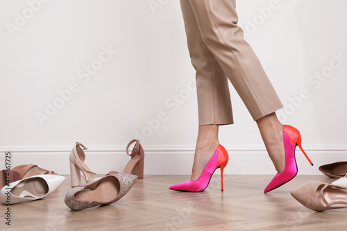 Картината върху платно Woman trying on different shoes indoors, closeup