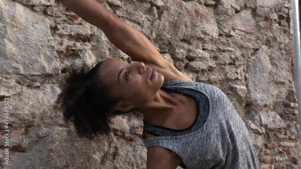 Young beautiful woman standing and exercising on street with arms outstretched Young beautiful woman standing and exercising on street with arms outstretched