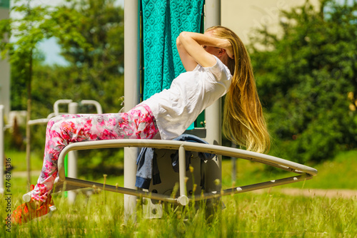 Girl doing situps in outdoor gym