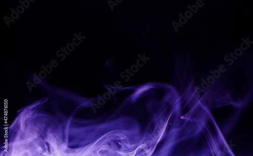 Abstract purple smoke moves on black background. Beautiful swirling violet smoke. Neon light.