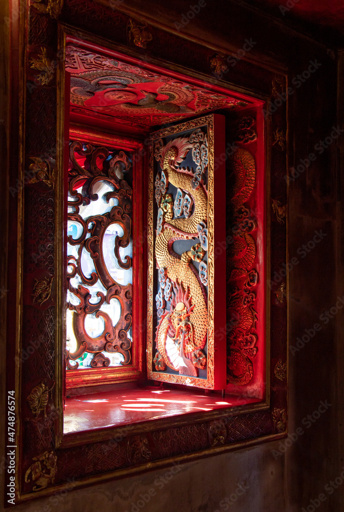 Carved shutters in an oriental temple. Richly decorated shutters with dragon theme, Chinese Buddhist monastery.