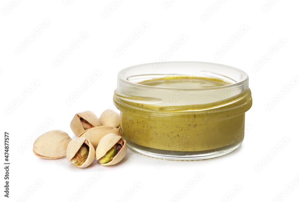 Jar with delicious pistachio butter and nuts on white background Jar with delicious pistachio butter and nuts on white background