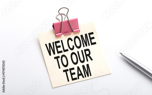 WELCOME TO OUR TEAM text on sticker with pen on the white background