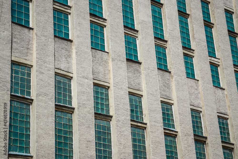 Facade of a building with many green windows Facade of a building with many green windows