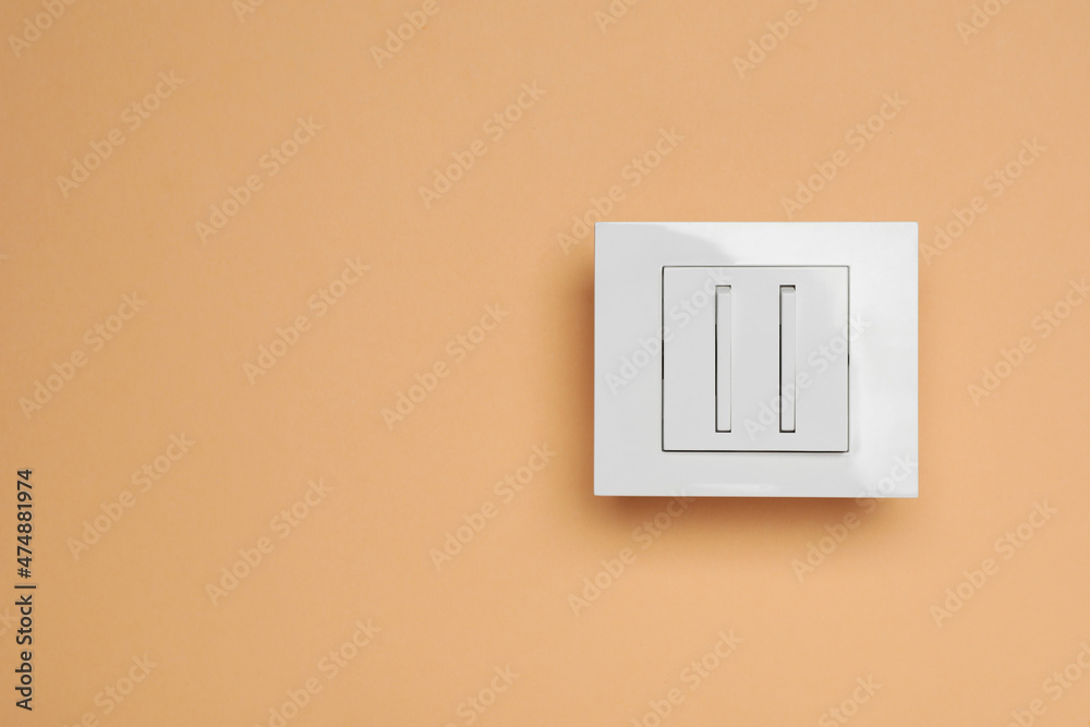 White light switch on orange background, top view. Space for text White light switch on orange background, top view. Space for text