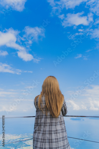 女性の後ろ姿と青空