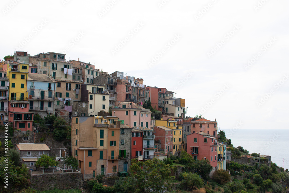 pastel italian houses on a mountain with a sky and cloudy background