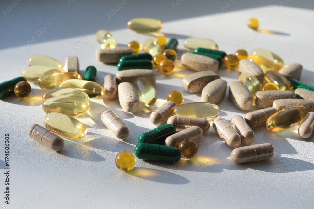 Many colourful pills, tablets and capsules medicinal drugs on the white surface. Therapeutic, healing effect, Pharmaceutics concept. Theme of Drugstore. Close up photo, copy space. Many colourful pills, tablets and capsules medicinal drugs on the white surface. Therapeutic, healing effect, Pharmaceutics concept. Theme of Drugstore. Close up photo, copy space.