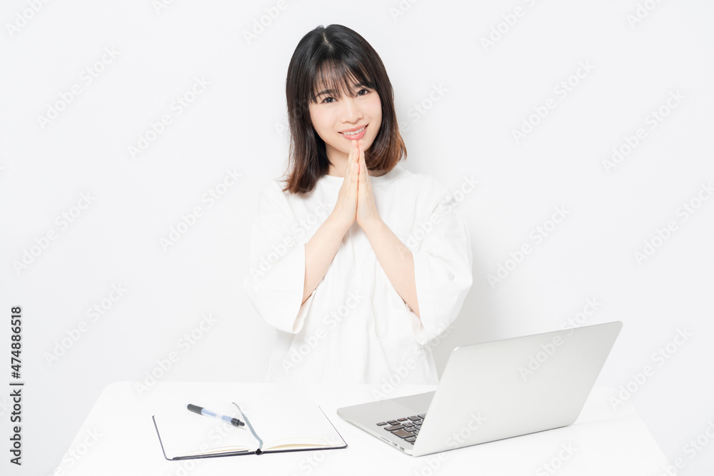 ノートパソコンを使いながら、願い事をする若い女性 ノートパソコンを使いながら、願い事をする若い女性