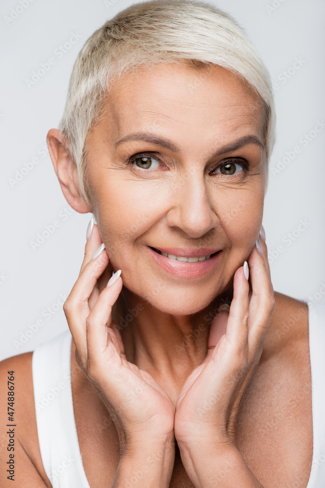 happy senior woman looking at camera isolated on grey happy senior woman looking at camera isolated on grey
