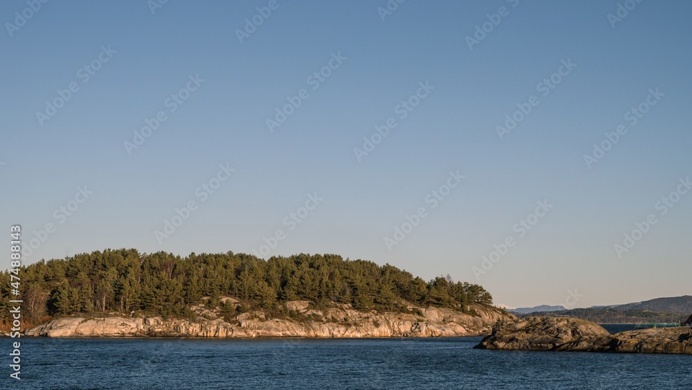 Landscape of trees on rocky islands in Lusefjord. Fjord cruise. Tourism in Norway. Beautiful nature on sunny day.