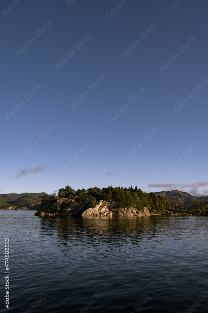 Landscape of trees on rocky islands in Lusefjord. Fjord cruise. Tourism in Norway. Beautiful nature on sunny day.