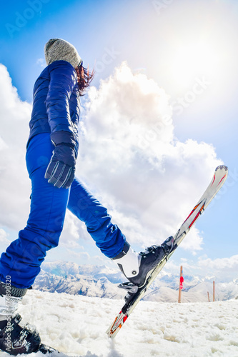Caucasian young woman in blue outfit look up to the blank sky. Ski holiday capture social media vertical promo vertical background