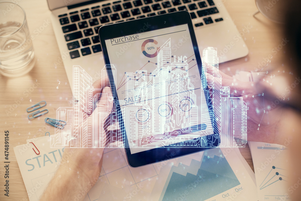 Double exposure of man's hands holding and using a digital device and city drawing.