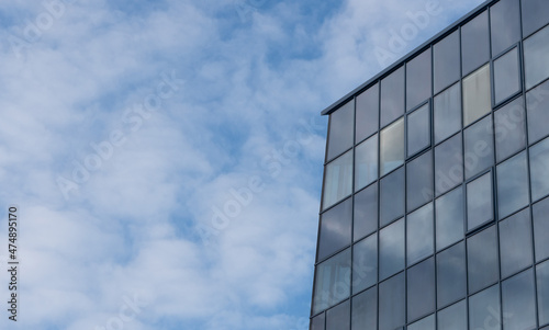 Skyscrapper building on a blue sky background with steel and glass.