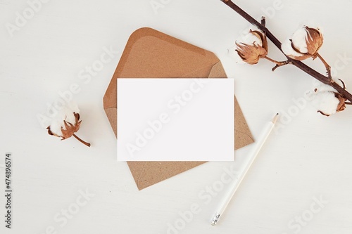A6 size card and brown envelope mockup, blank horizontal postcard, notecard for text or design presentation, cotton branches decoration.