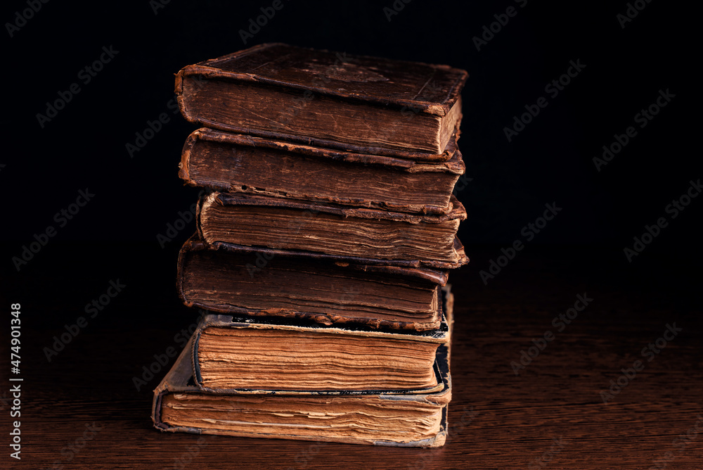Closeup of old shabby Jewish books in stack in the darkness. Selective focus.