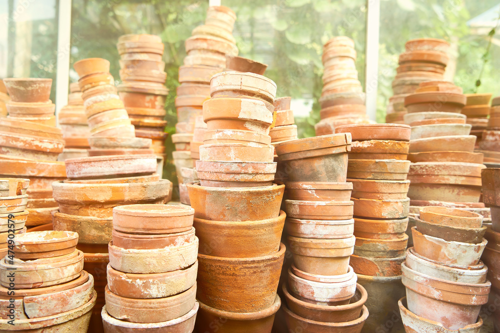 A sunny image of stacks of old and used clay plant pots A sunny image of stacks of old and used clay plant pots