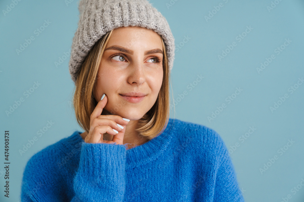 Young blonde woman wearing knit hat smiling at camera Young blonde woman wearing knit hat smiling at camera
