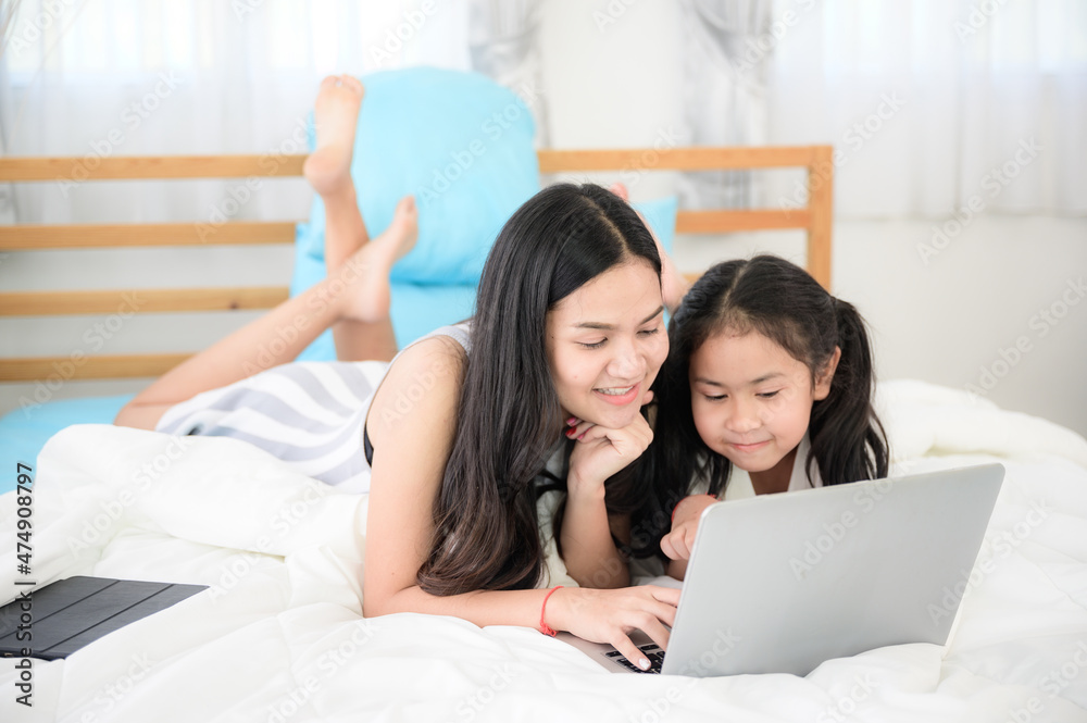 child girl person 2 sisters watching media and learning on laptop, online communication at home child girl person 2 sisters watching media and learning on laptop, online communication at home