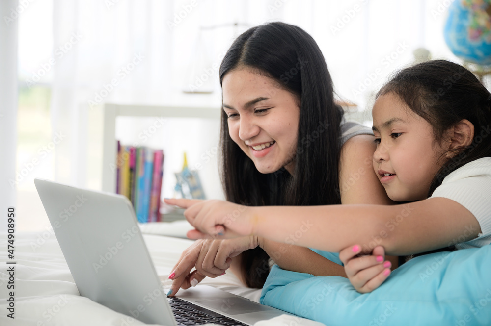 child girl person 2 sisters watching media and learning on laptop, online communication at home child girl person 2 sisters watching media and learning on laptop, online communication at home