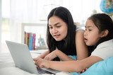 child girl person 2 sisters watching media and learning on laptop, online communication at home