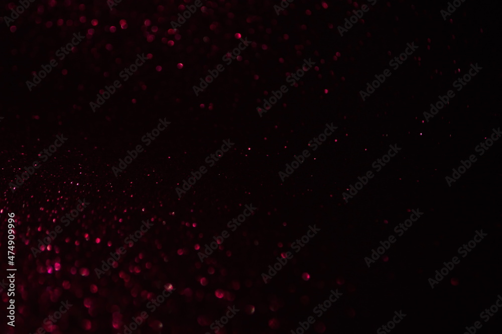 Glittering festive red and black background. Concept of New Year celebration. defocused blurred background