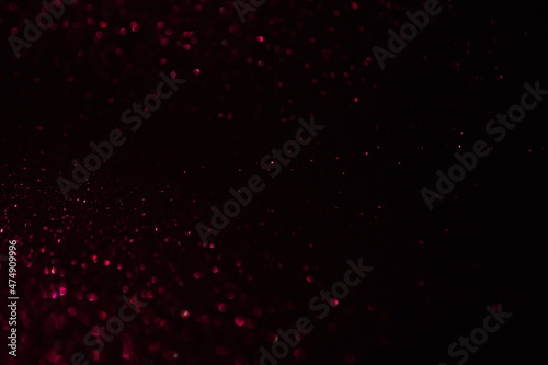Glittering festive red and black background. Concept of New Year celebration. defocused blurred background