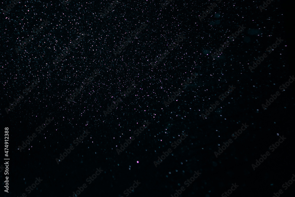 abstract purple on black bokeh background overlay layer. sparks and blowing. festive background. Sparkling magical dust particles.