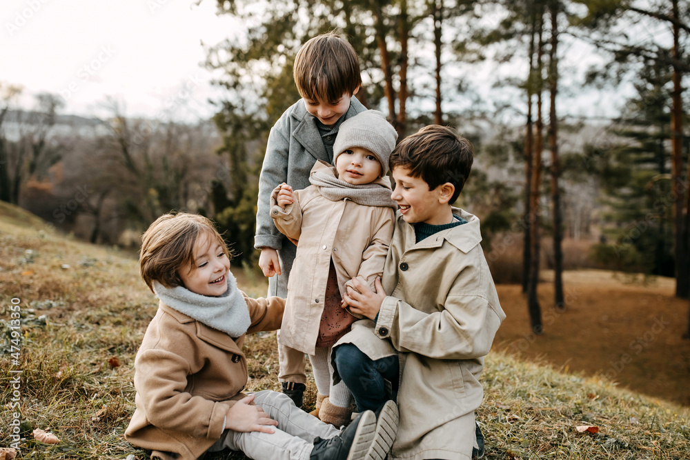 Brothers and sister spending time outdoors in a park on autumn day. Brothers and sister spending time outdoors in a park on autumn day.