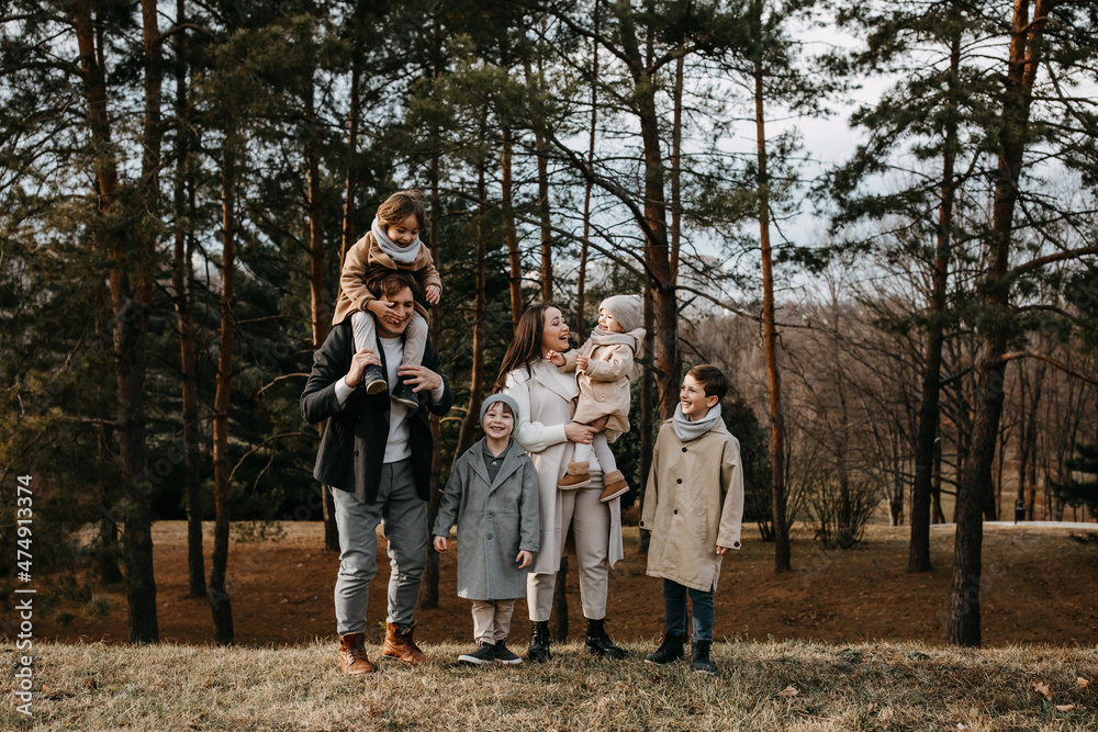 Fototapeta premium Big family with four children outdoors. Family spending time together on an autumn day.