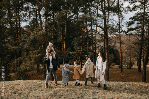 Big family walking outdoors in a forest. Family spending fun time together on an autumn day.