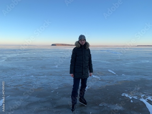 a man in a winter jacket ice skating on the frozen Volga river