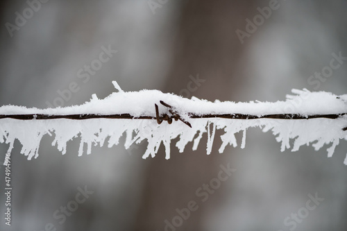 Metal wires covered with frost snow and snowflakes photo