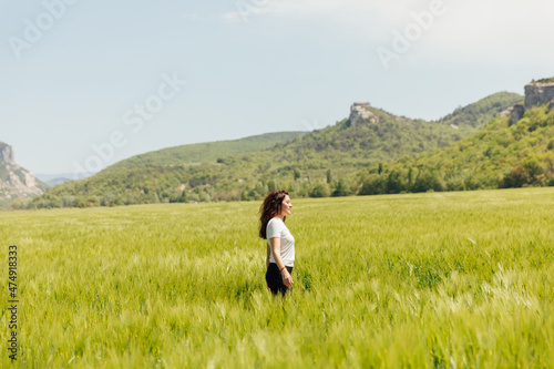 woman tourist walking through a field of wheat on a journey © dmitriisimakov