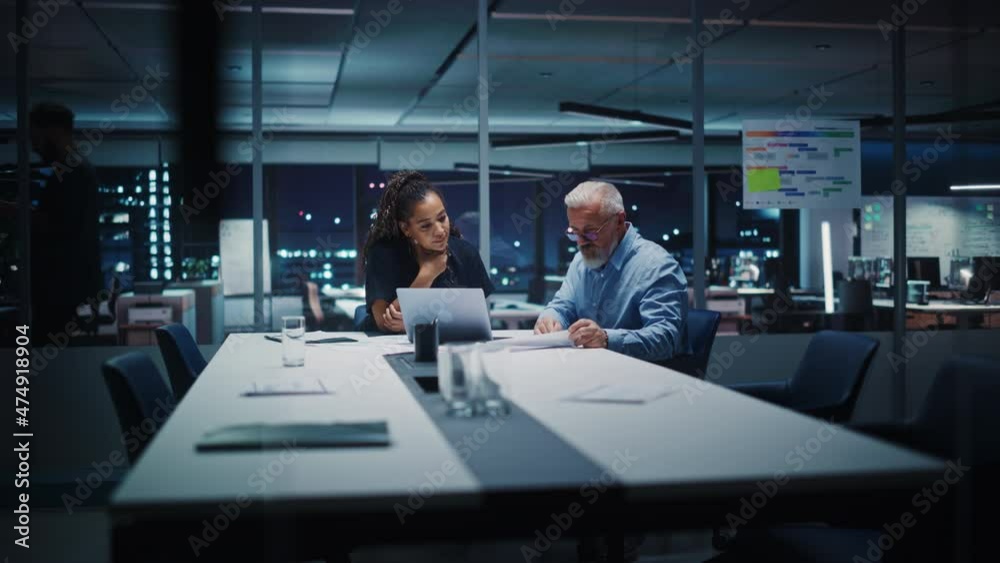 Businesspeople in Modern Office: Business Meeting of Two Managers. Female CEO and Operations Director Talk, Discuss Corporate Strategy, Implementing Marketing and Financial Plans. Evening Time. Businesspeople in Modern Office: Business Meeting of Two Managers. Female CEO and Operations Director Talk, Discuss Corporate Strategy, Implementing Marketing and Financial Plans. Evening Time.