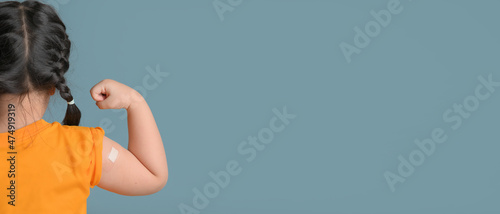Foto Little asian girl with bandage plaster on her arm after Covid-19 vaccination