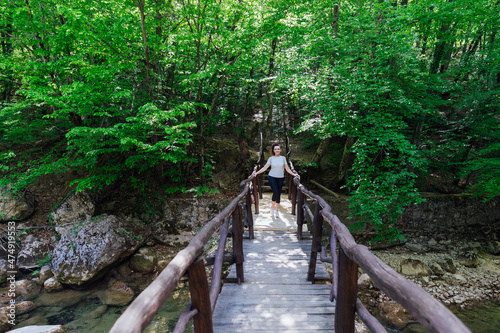 beautiful tourist woman walking through the green forest on a journey