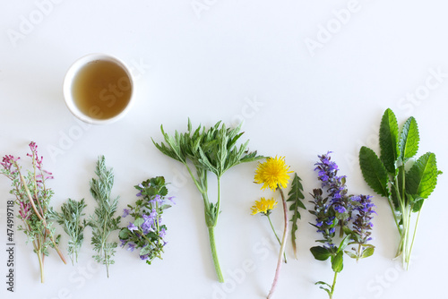 Edible flowers collection and a cup of tea isolated on white background. Top view.
