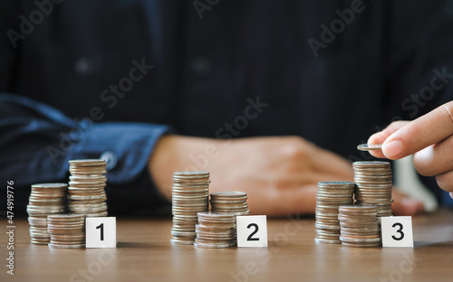 businessman hand stacking coins for finance investment management by portfolio diversification for distributing risks and increasing opportunities photo