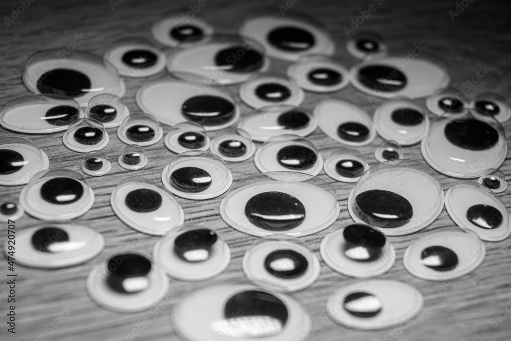 Many plastic eyes on a wooden background. Lots of eyes. Many plastic eyes on a wooden background. Lots of eyes.