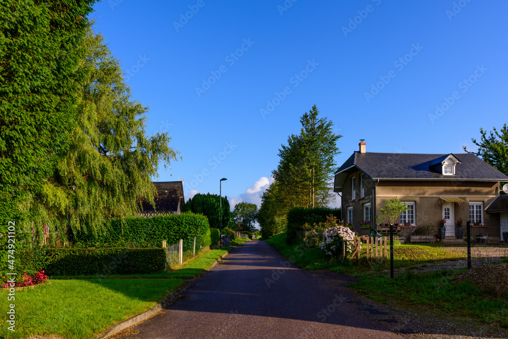 The street of the traditional French village of Saint Sylvain in Europe, France, Normandy, towards Veules les Roses, in summer, on a sunny day. The street of the traditional French village of Saint Sylvain in Europe, France, Normandy, towards Veules les Roses, in summer, on a sunny day.